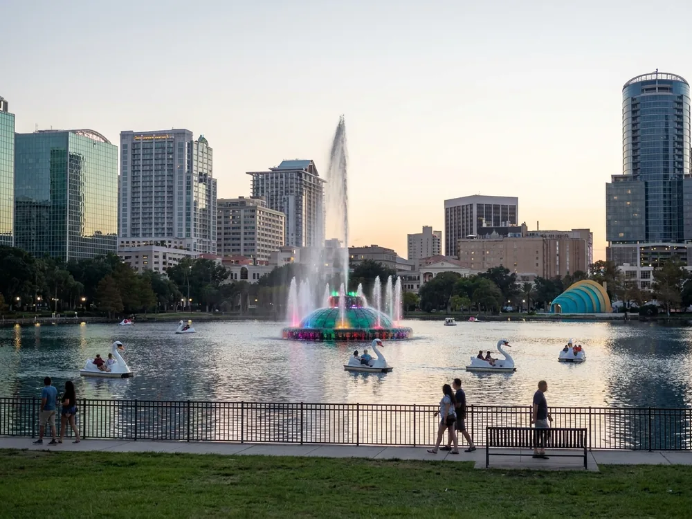 Lake Eola fountain and swan boats with the Orlando skyline